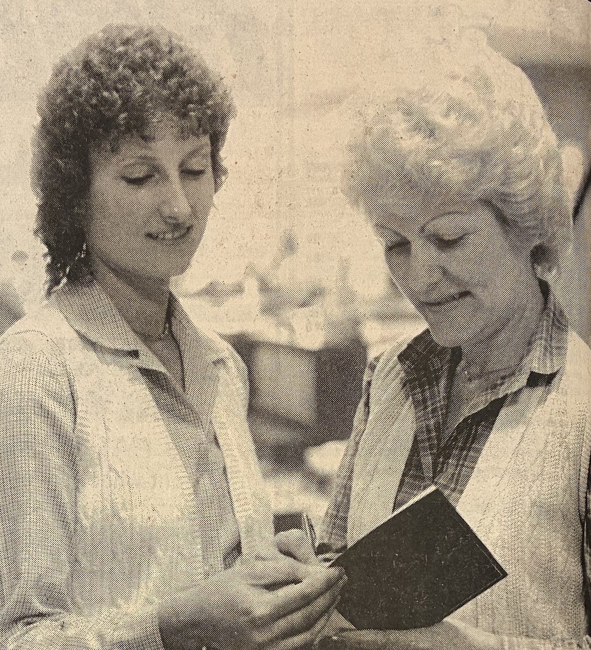 Debbie Shour of Coeur d’Alene, left, helps Trish Hildebrand sign a get-well card for wounded President Ronald Reagan in 1981.