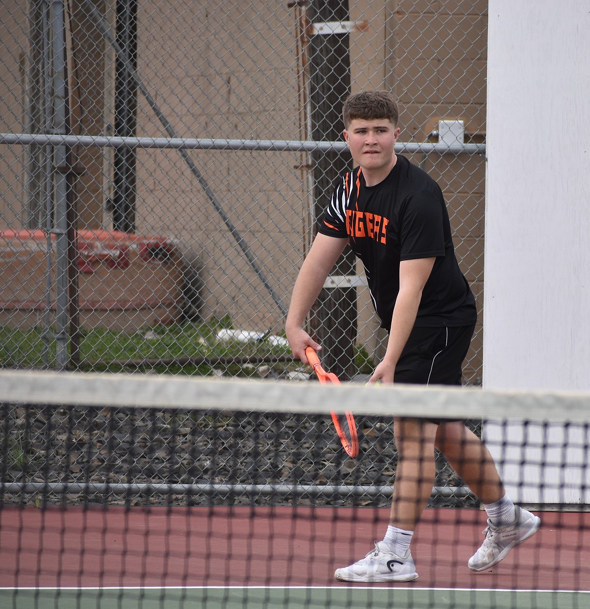 Avery Morris from the Tigers prepares to serve the ball to the opposing Huskies player Max Harris in the number one singles matchup Tuesday afternoon.