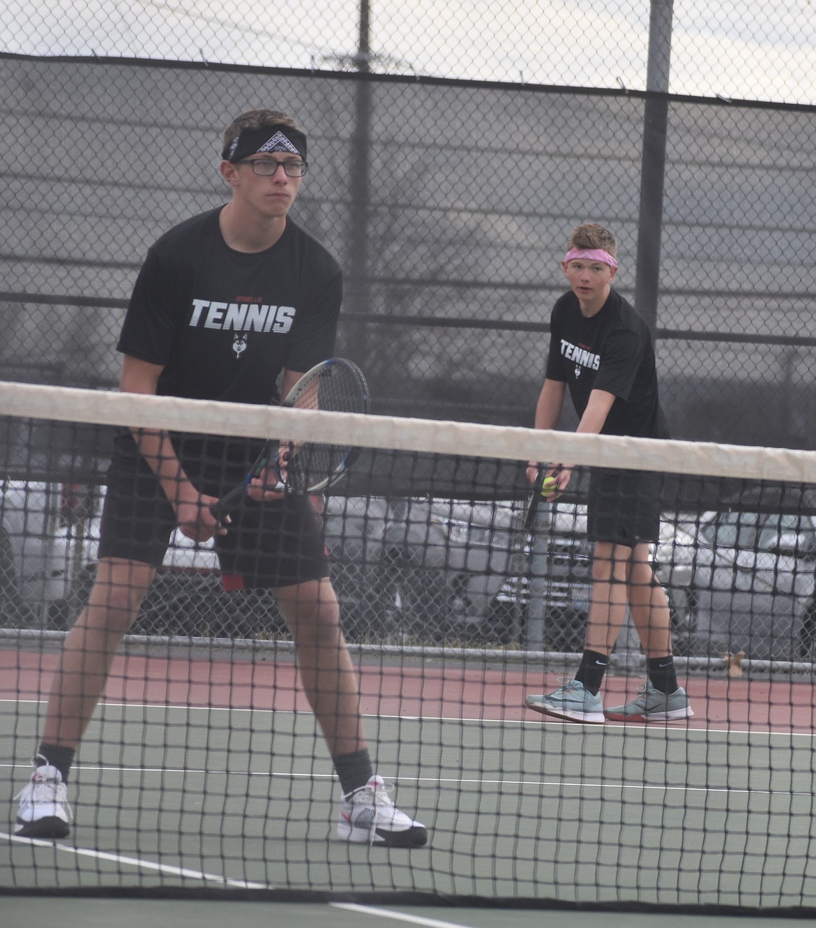 Huskies number one doubles team with Ben Meredith (black bandana) at the net and Jace Ritchie (pink bandana) getting ready to serve.
