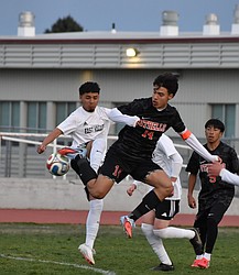 Huskies senior Luis Farias leaps in the air along with an East Valley player as they collide for possession of the ball. Farias said the Huskies knew it was going to be a competitive game, but they stuck it out and held their own.