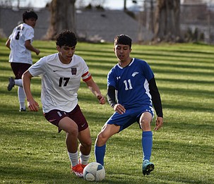 Icker Lopez (17), a junior from the Warriors, and Joshua Morales, a sophomore from the Cougars, battle for possession of the ball during Thursday’s game.