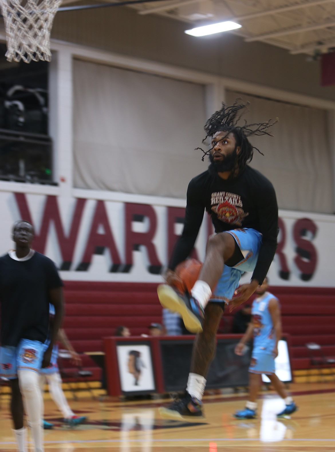 The Red Tails’ Jaylon Gibson, in black shirt, practices a between- the-legs layup ahead of their game Saturday.