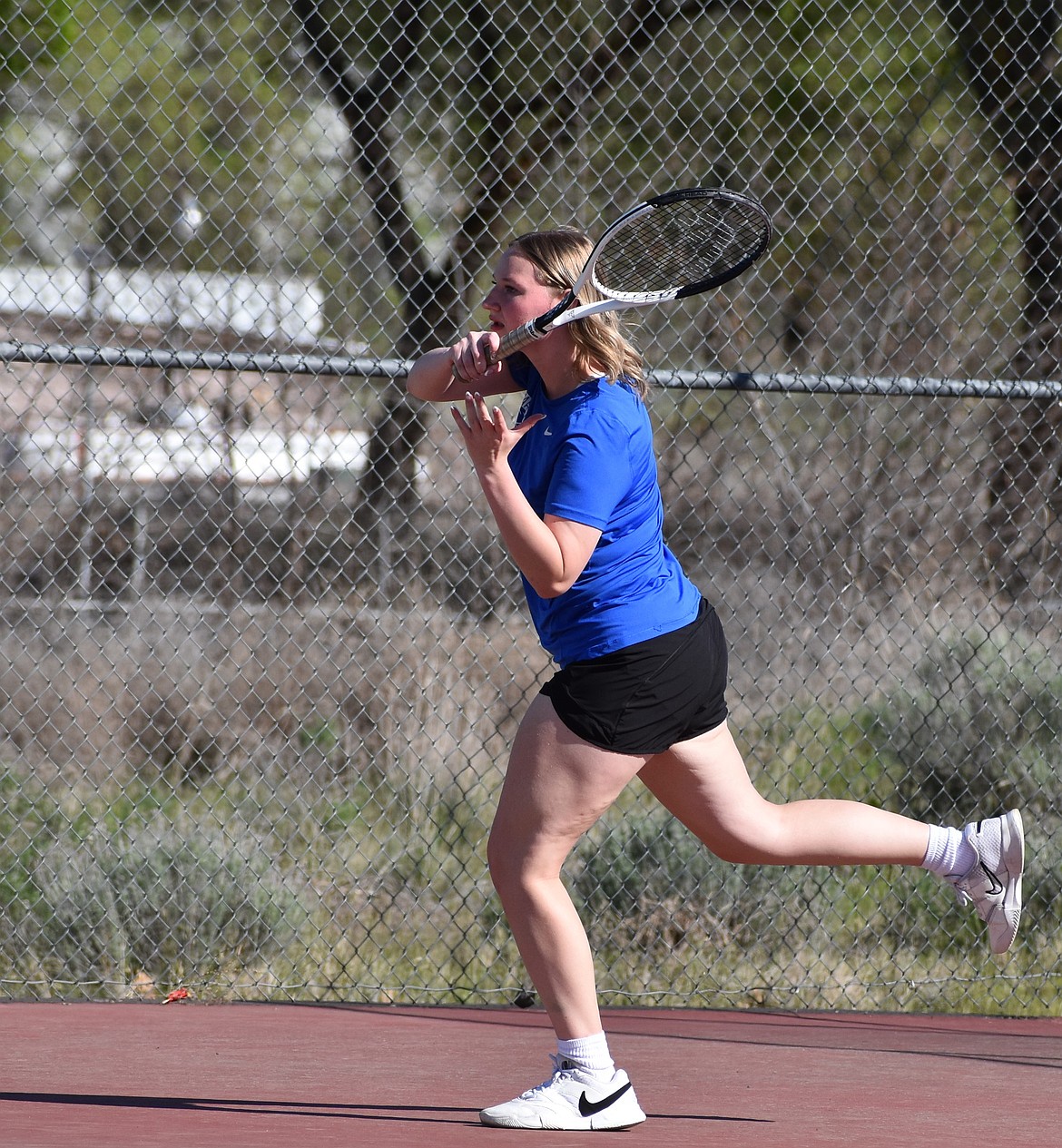 Riley Frazier from the Eagles swings and hits the ball back at the opposing doubles team during Monday afternoon’s match against Entiat.