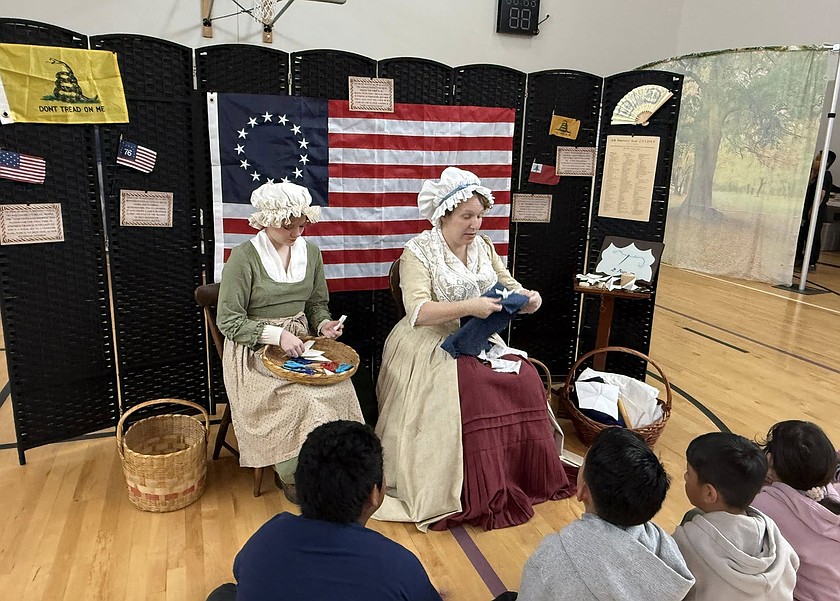 Betsy Ross and a companion sew stars on the American flag in the Quincy Valley Historical Society’s traveling exhibit “Journey to Philadelphia 1776.”
