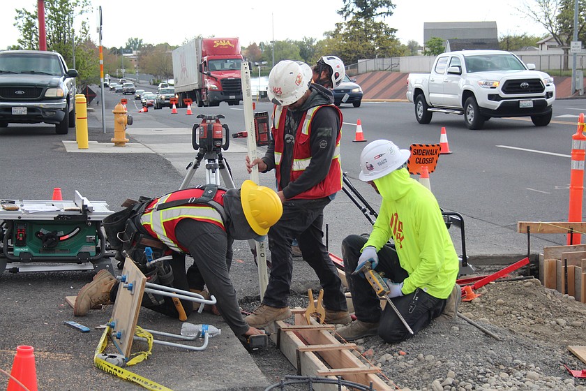 Construction workers level the forms for a new sidewalk on Stratford Road in Moses Lake Thursday.