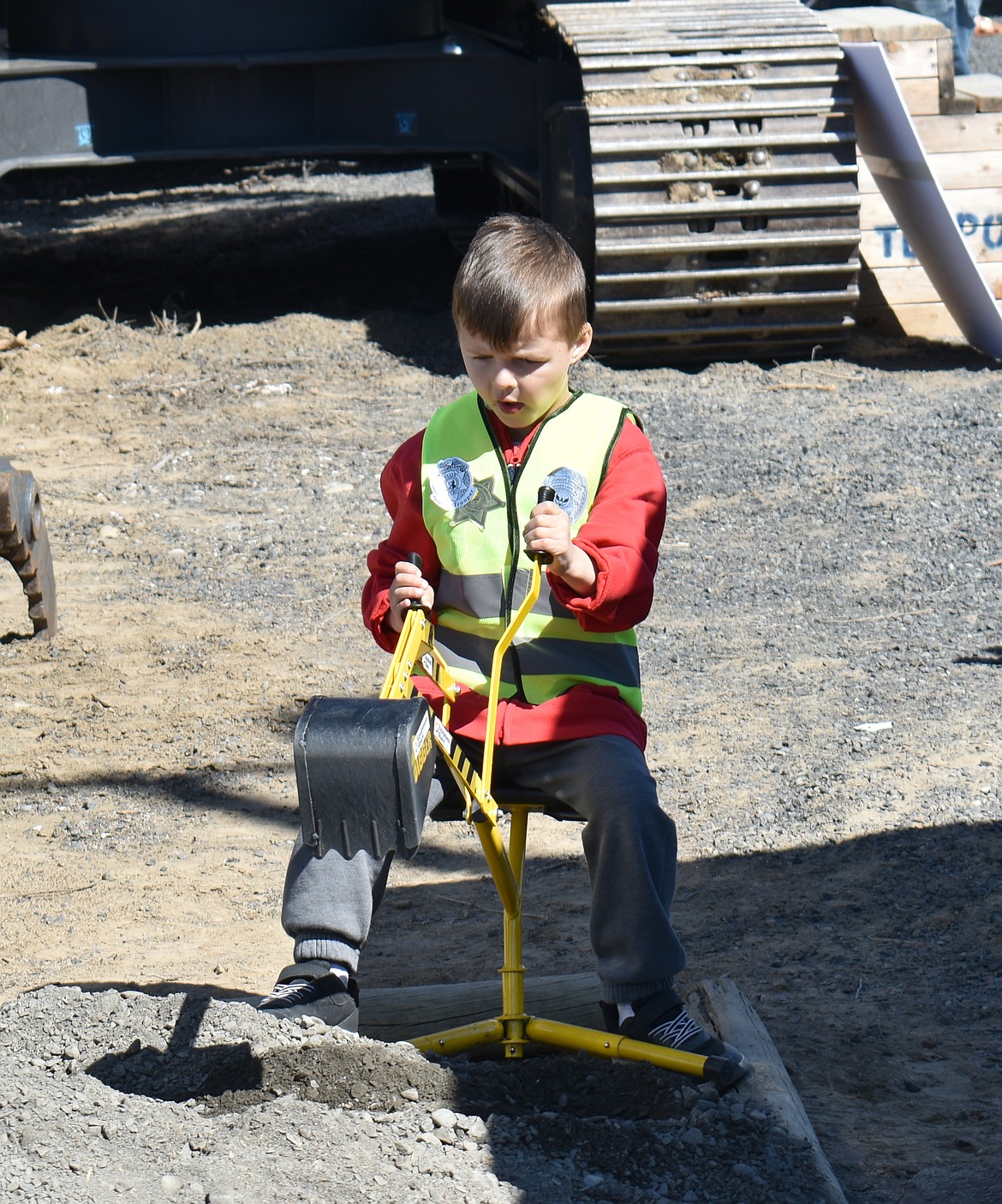 Azariah Beregovoy, 4, takes a break from climbing on heavy equipment to do some excavating of his own at Touch a Truck Saturday morning.