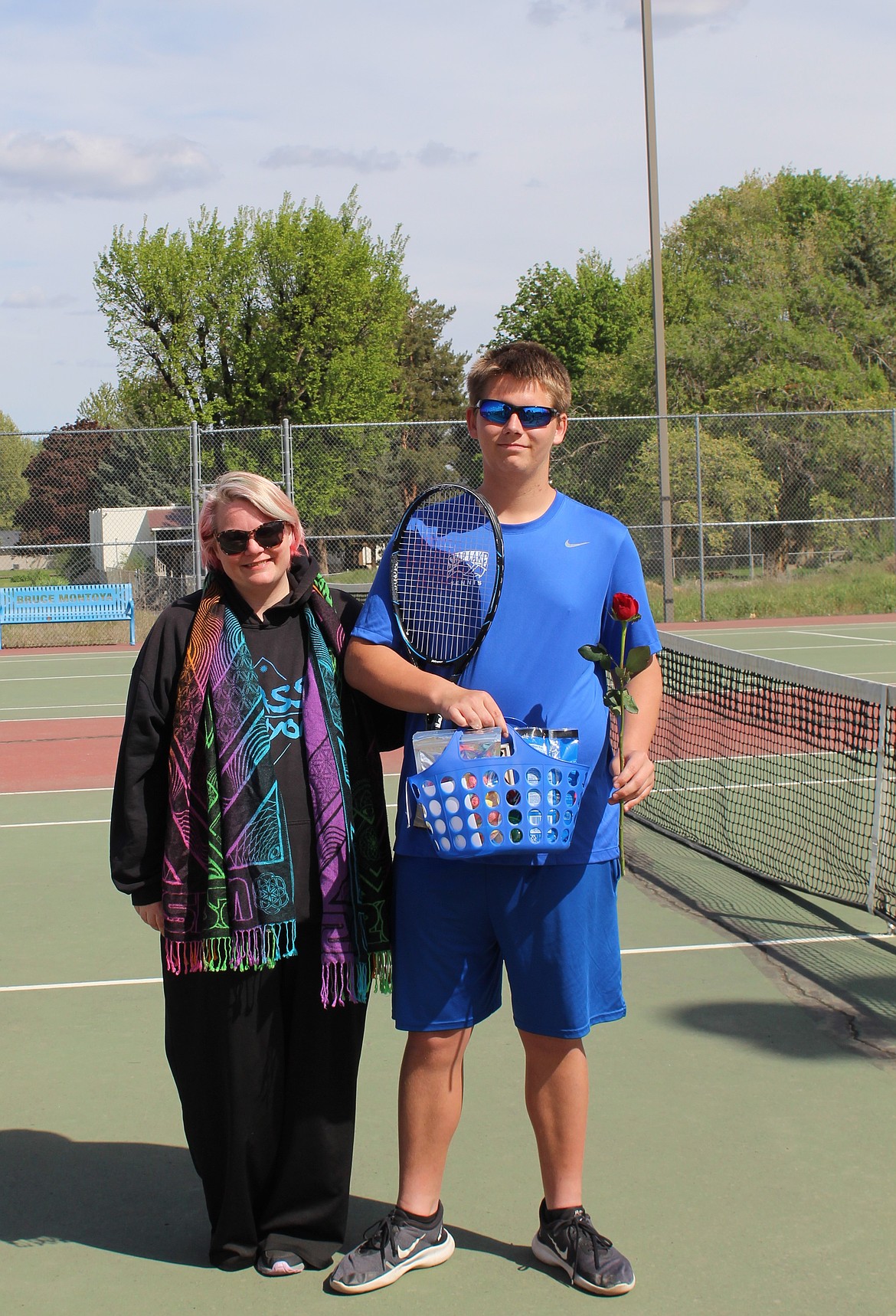 Soap Lake’s Christian Minneker, right, stands on the court with his senior basket and rose in hand Tuesday afternoon.