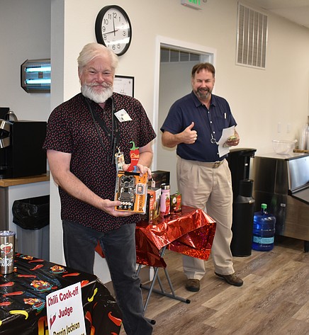 Gary Neu holds up the trophy and prize he won with his Cooper’s Revenge chili at Greenpoint Technologies’ annual chili cookoff April 27.