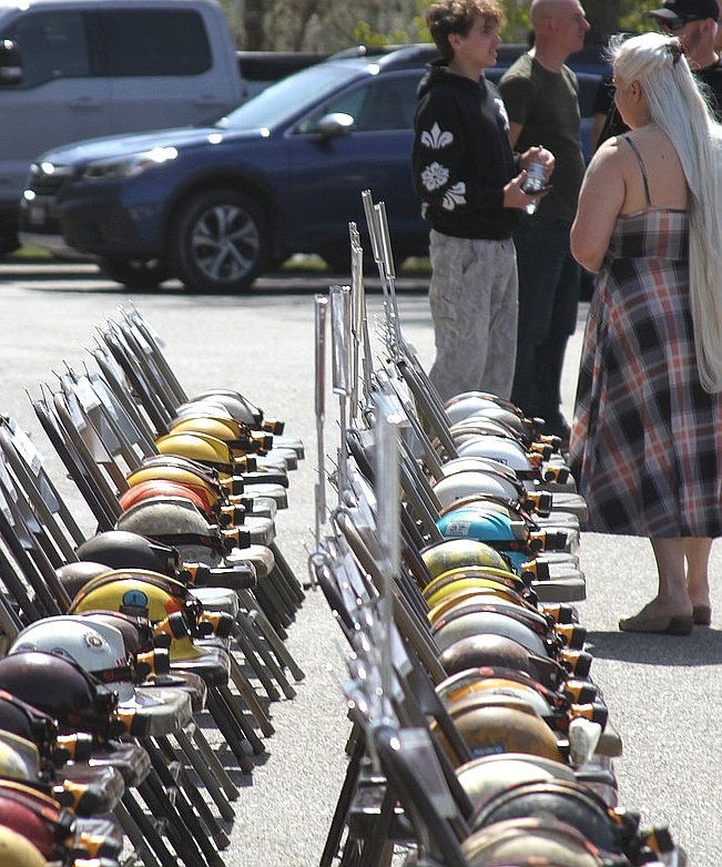 A woman slowly reads the names on the 91 helmets that belonged to the fallen miners during the Sunshine Mine Disaster Memorial.