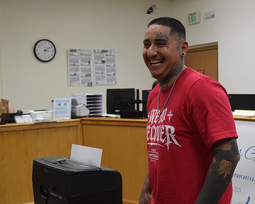 Community Court Graduate Abel Valdez shreds several of his court cases that were formally dismissed after he graduated from the court.