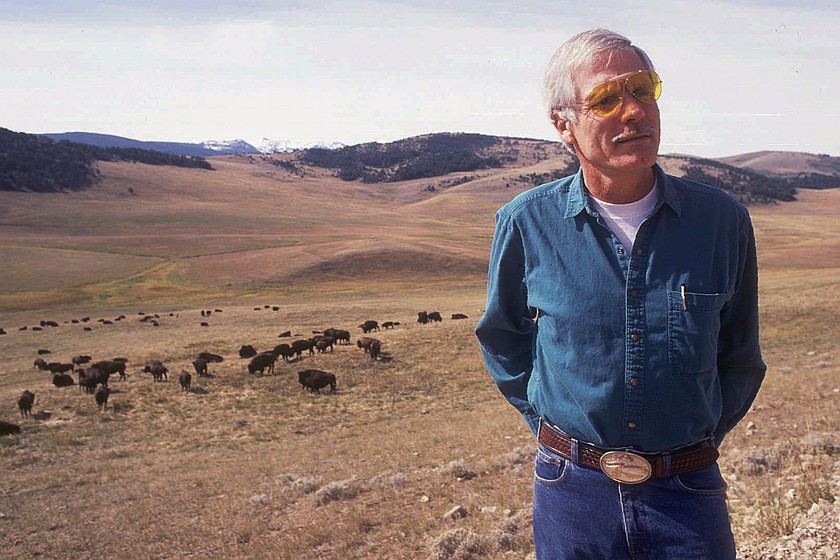 FILE - Ted Turner poses near a herd of his bison in September 1991 at his Flying D Ranch near Bozeman, Mont. (Linda Best/Bozeman Daily Chronicle via AP, File)