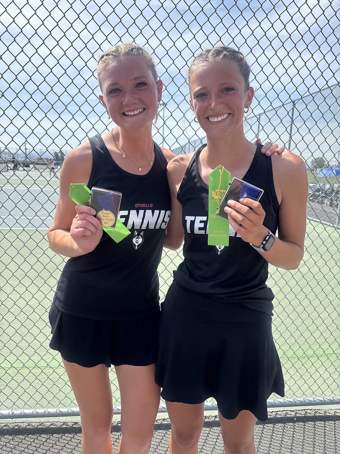 Huskies number one doubles team, Shaylee Freeman and Faith Risenmay, hold up their medals after taking first in the doubles tournament and becoming 2A District 5 champions.