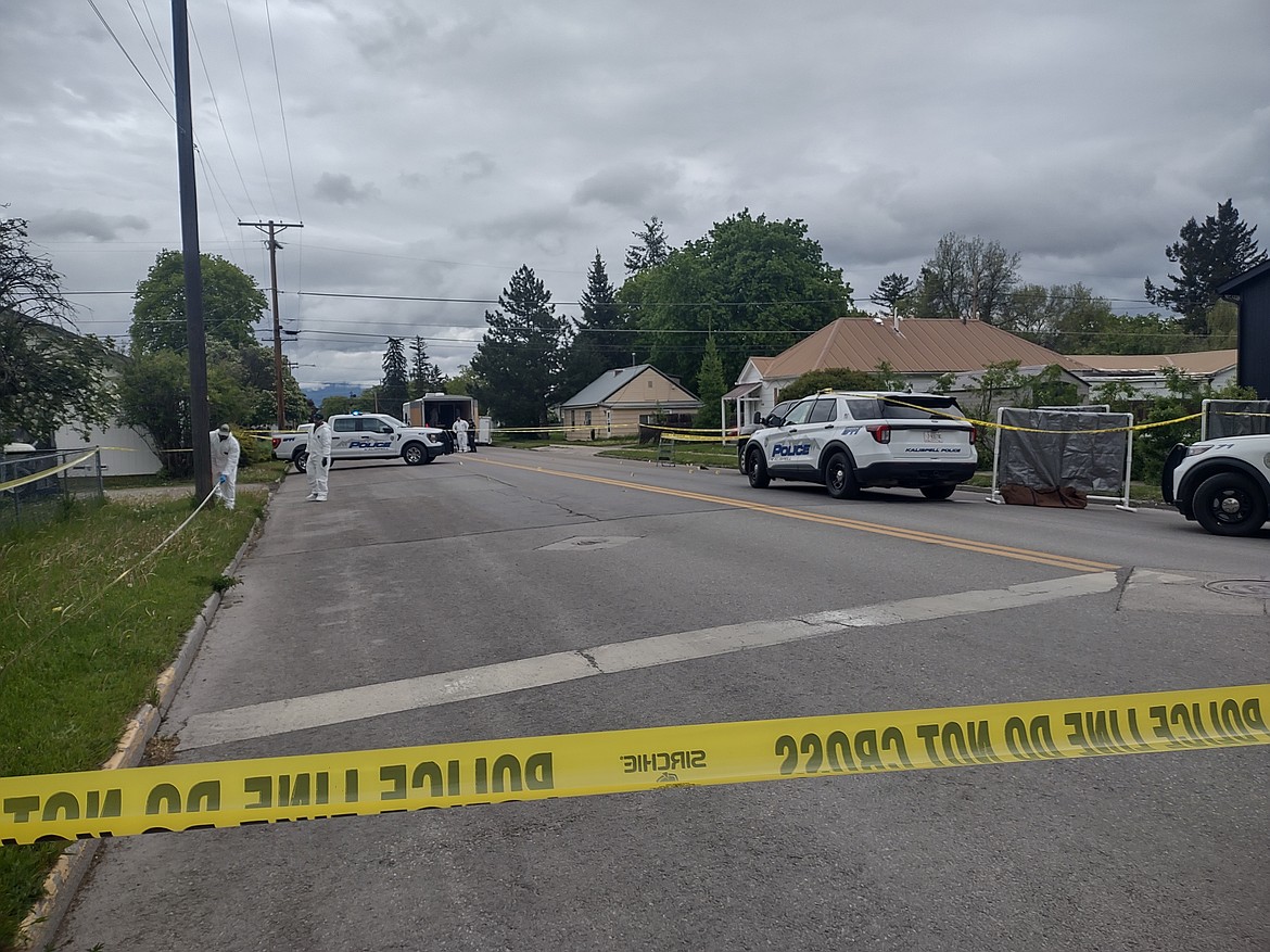 Investigators work behind police tape near the intersection of Second Street West and 10th Avenue West in Kalispell on Saturday, May 16. (Derrick Perkins/Daily Inter Lake)