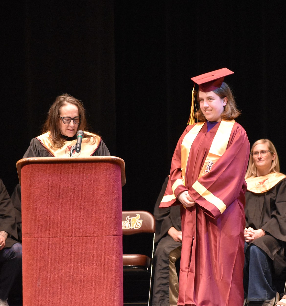 Kyleigh Mickle stands on stage next to the podium as she is recognized for all her achievements at MLHS.