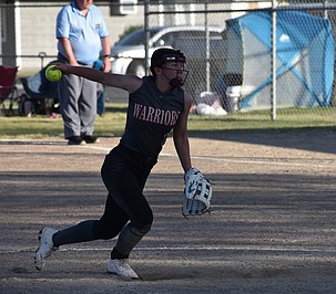 Grace Okamoto, a junior from the Warriors, puts her focus on the opposing batter as she gears up to hurl a pitch in a previous away game this season.
