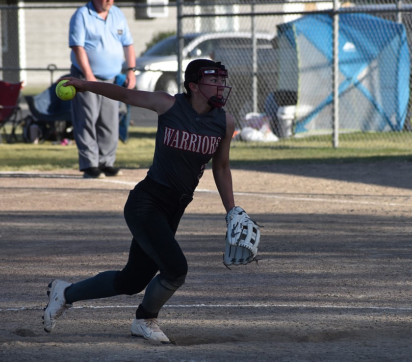 Grace Okamoto, a junior from the Warriors, puts her focus on the opposing batter as she gears up to hurl a pitch in a previous away game this season.