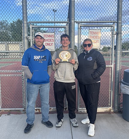 Eagles Head Coach Lee Leavell, senior Xavier Ewing and Assistant Coach Clarissa Larsen stand together with Ewing holding the hardware for the boys team earning the 1B District 5 title.