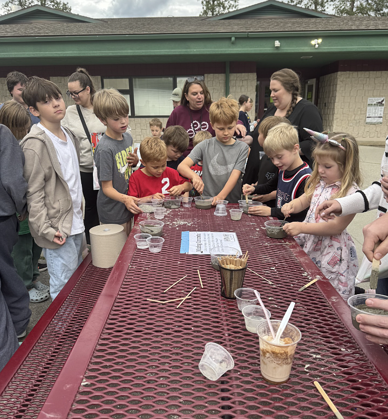 Lucca and Rocco Domanico and Leo and Waylon Hills, center, and other students with teacher Mandi Ferguson learn to mix cement with HMH Engineering during the May 14 "Exploring Our World" STEM night at Fernan STEM Academy.