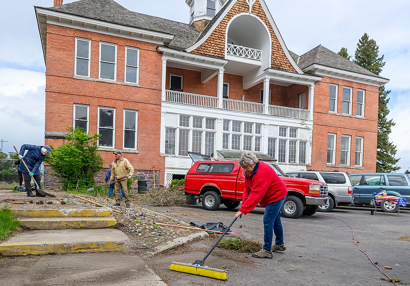 Lois Smith, foreground, of the Columbia Falls Historical Society, helps clean up around the Old Main at the Montana Veterans Home.