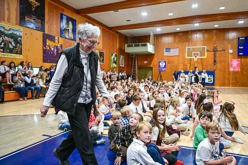 Sister Judy Lund walks to the front of the gymnasium to accept the Spirit of Montana Award from Gov. Greg Gianforte at St. Matthew's Catholic School in Kalispell on Wednesday, May 20. (Casey Kreider/Daily Inter Lake)