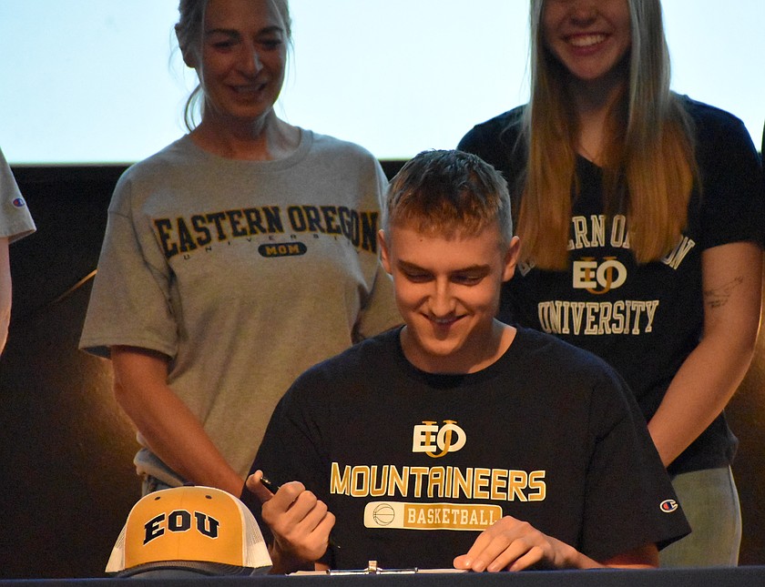 Johnny Ferguson signs his letter of intent to continue his basketball career with Eastern Oregon University.