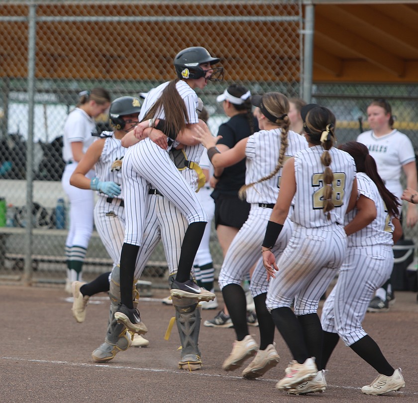 The Knights dugout clears and swarms Livi Wardenaar, being held up, after her line drive scored the game winning run against Klahowya in the first round of the 1A state softball tournament.