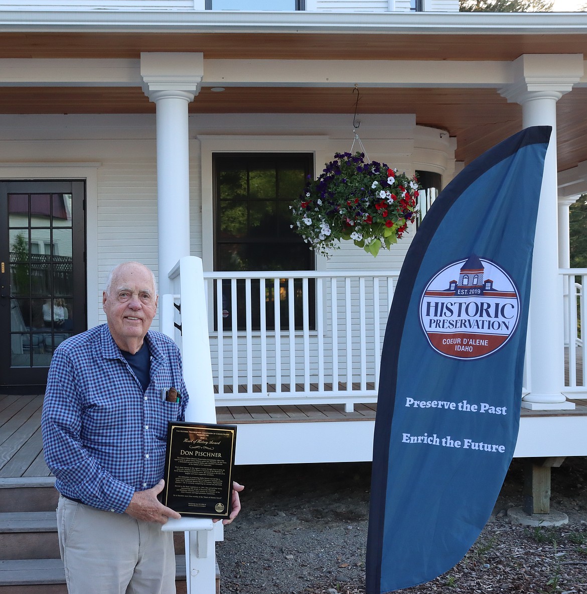 Don Pischner holds his award plaque in front of the Museum of North Idaho.
