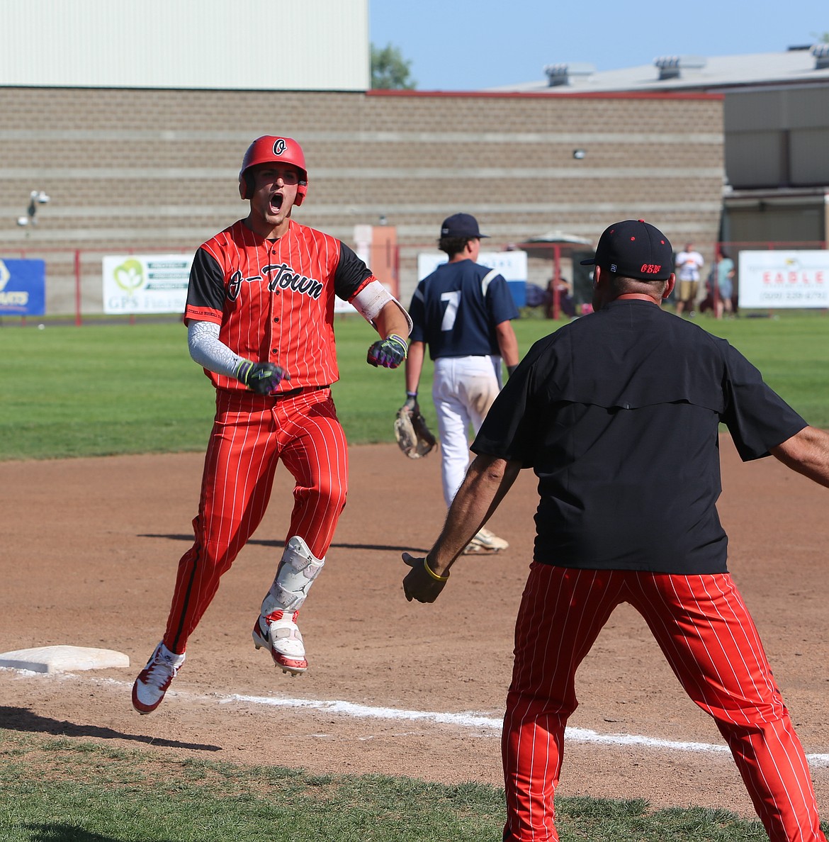 An energetic RJay Garza runs past Heads Coach Sonny Garza after hitting a home run against Selah Saturday.