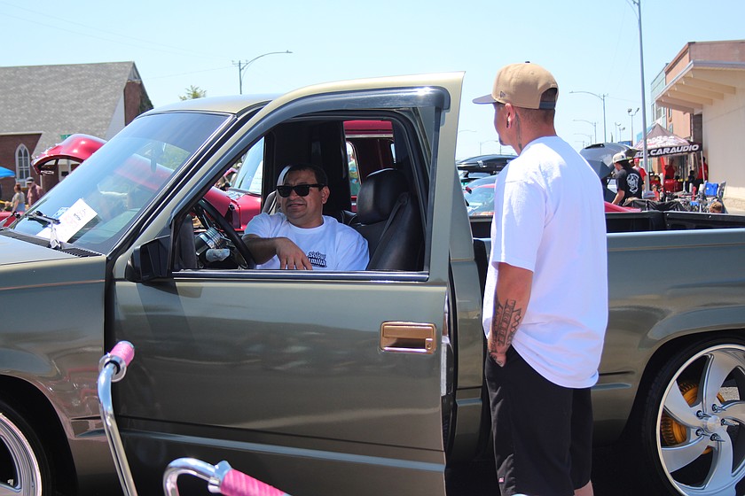 Junior Rios talks with a friend about his restored 1989 Chevy during the Spring Festival car show, sponsored by the Lakesiders Car Club.