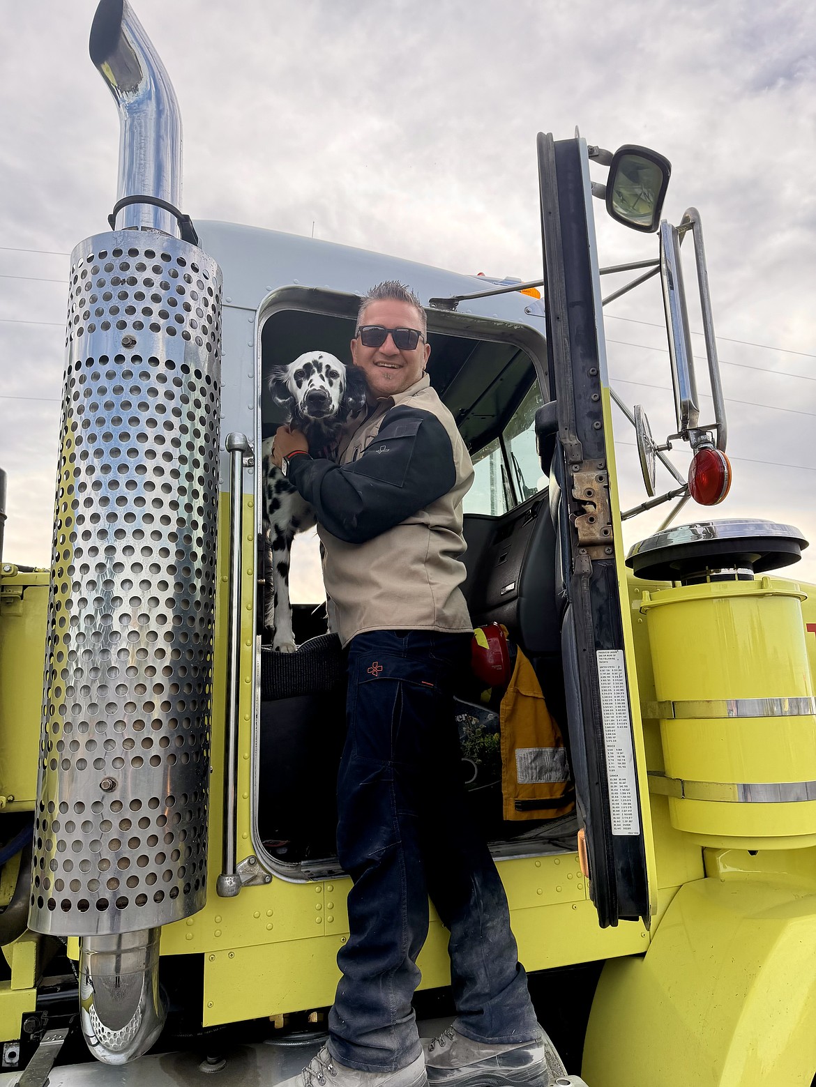 Grant County Fire District 5 Battalion Chief Travis Svilar checks on the district's fire dog, Ember, after a fire is contained Sunday.