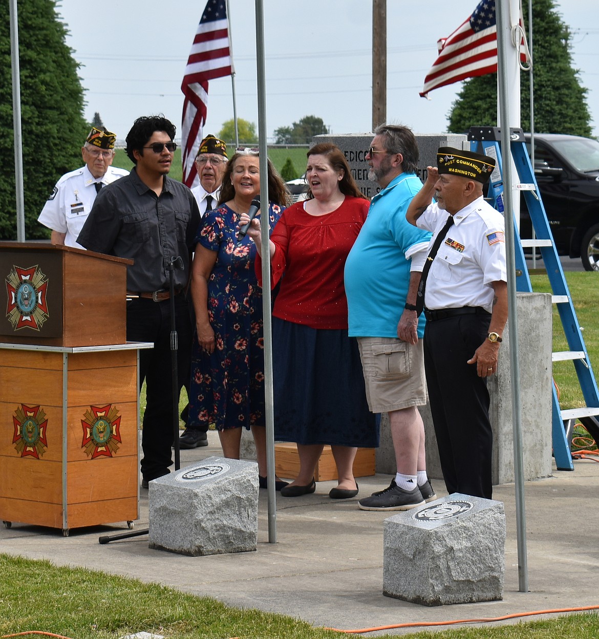 From left: Robbie Flores, Kimmy Sanders, Joanna Miller and Steve Agenbroad sing “The Star-Spangled Banner” at Bess Hampton Memorial Gardens Monday.
