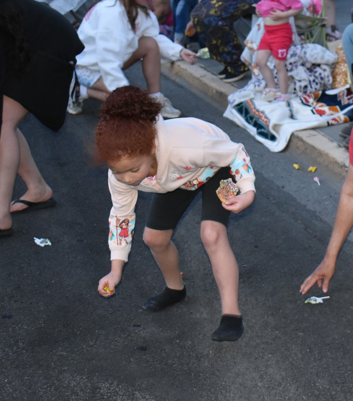 Abigail Flores, 6, scoops up some candy at the Spring Fest Parade Saturday.