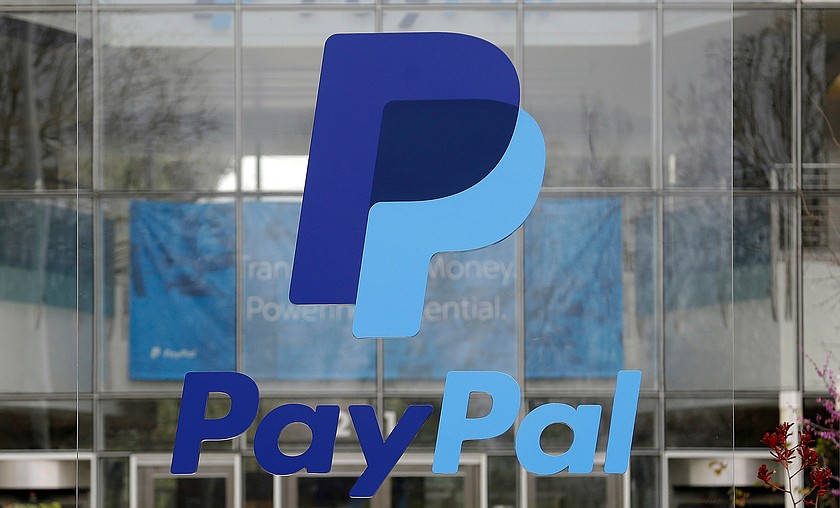 The PayPal logo hangs displayed outside their company headquarters on March 10, 2015, in San Jose, Calif. (AP Photo/Jeff Chiu, File)