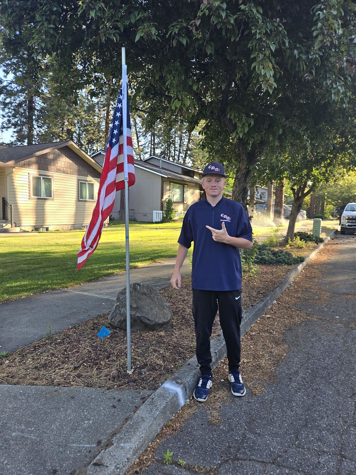 Courtesy photo  
Coeur d'Alene Legion class AA player Justin Fagan poses with a flag on Monday. Members of the Coeur d'Alene Lumbermen American Legion baseball program’s class AA team spent Memorial Day placing roughly 300 flags at residences in the community in the morning, then members of the 16U team collected them that night. The flag project is a partnership with the Lumbermen and the Kiwanis club. It honors the nation by displaying flags in neighborhoods in Coeur d'Alene, and helps develop a service attitude in the players.
