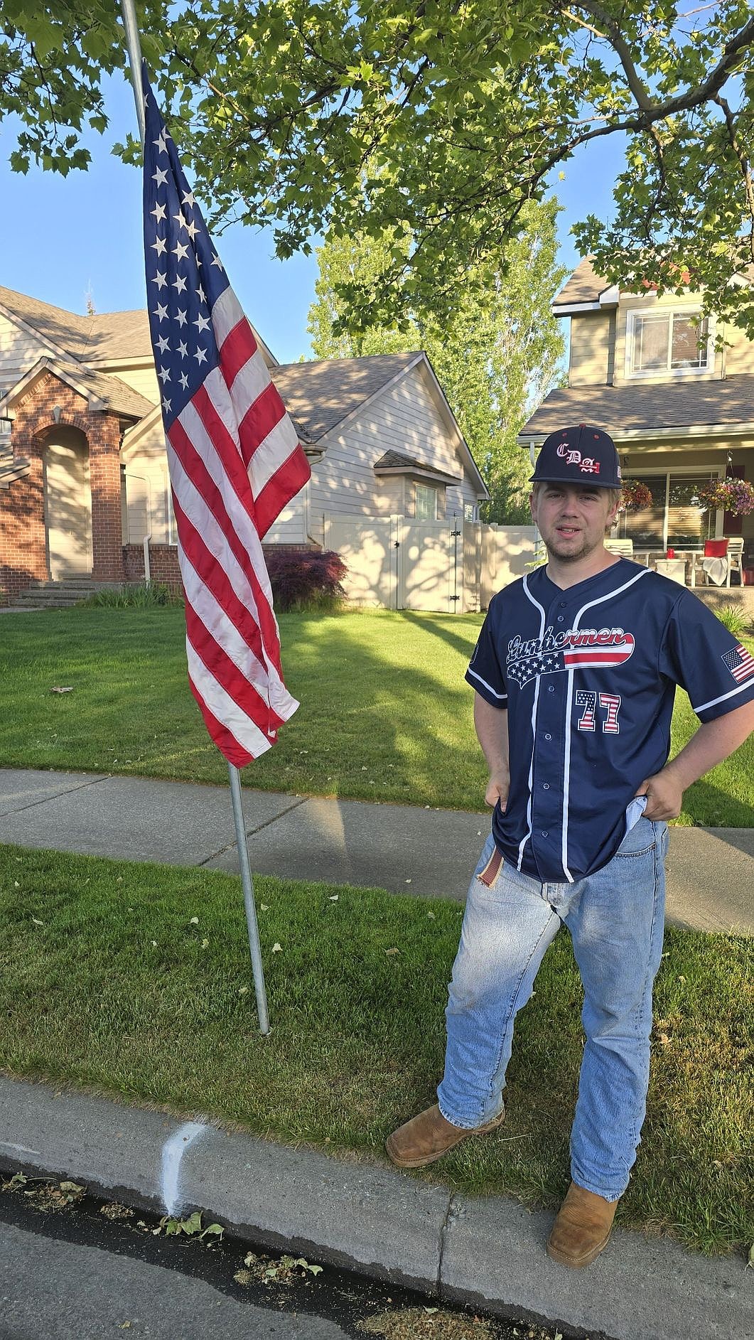 Courtesy photo  
Coeur d'Alene class AA player Rylan Anstine poses with a flag on Monday. Members of the Coeur d'Alene Lumbermen American Legion baseball program’s class AA team spent Memorial Day placing roughly 300 flags at residences in the community in the morning, then members of the 16U team collected them that night. The flag project is a partnership with the Lumbermen and the Kiwanis club. It honors the nation by displaying flags in neighborhoods in Coeur d'Alene, and helps develop a service attitude in the players.