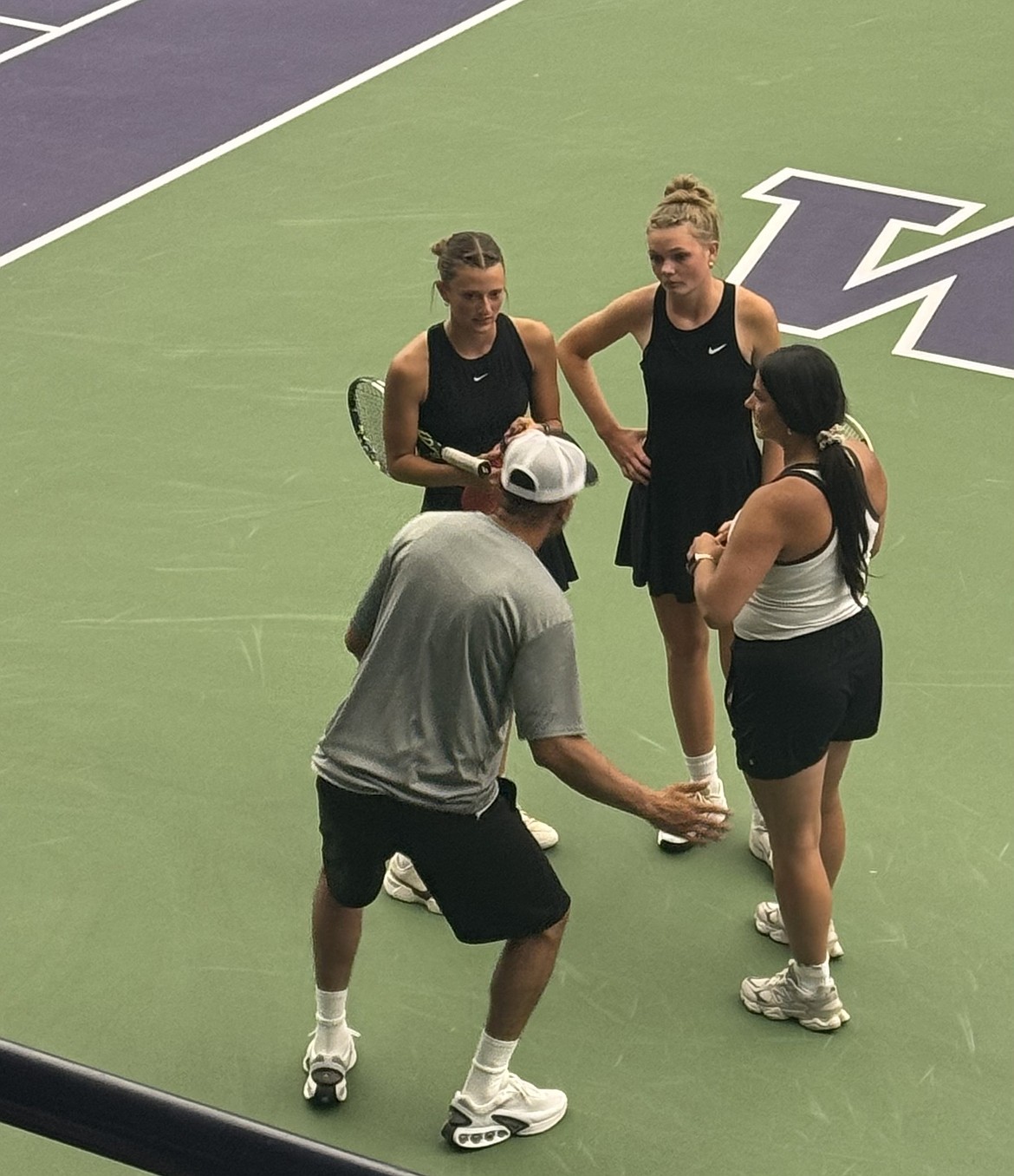 Huskies’ senior duo Faith Risenmay and Shaylee Freeman talk with their coaches Caleb Tovar and Priscilla Tovar in between sets at the state tournament in Seattle.