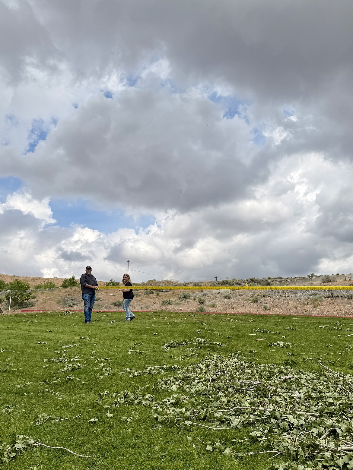 Two Moses Lake Irrigation and Rehabilitation District employees work on blocking off Connelly Park Friday morning. The park is closed to the public until the fallen trees and widow makers can be removed from the area.