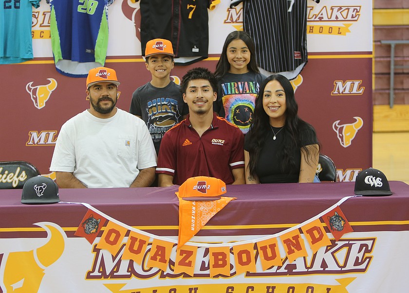 Noah Hernandez (maroon polo) sits surrounded by his family as he signs to play college baseball at Ottawa University Arizona.