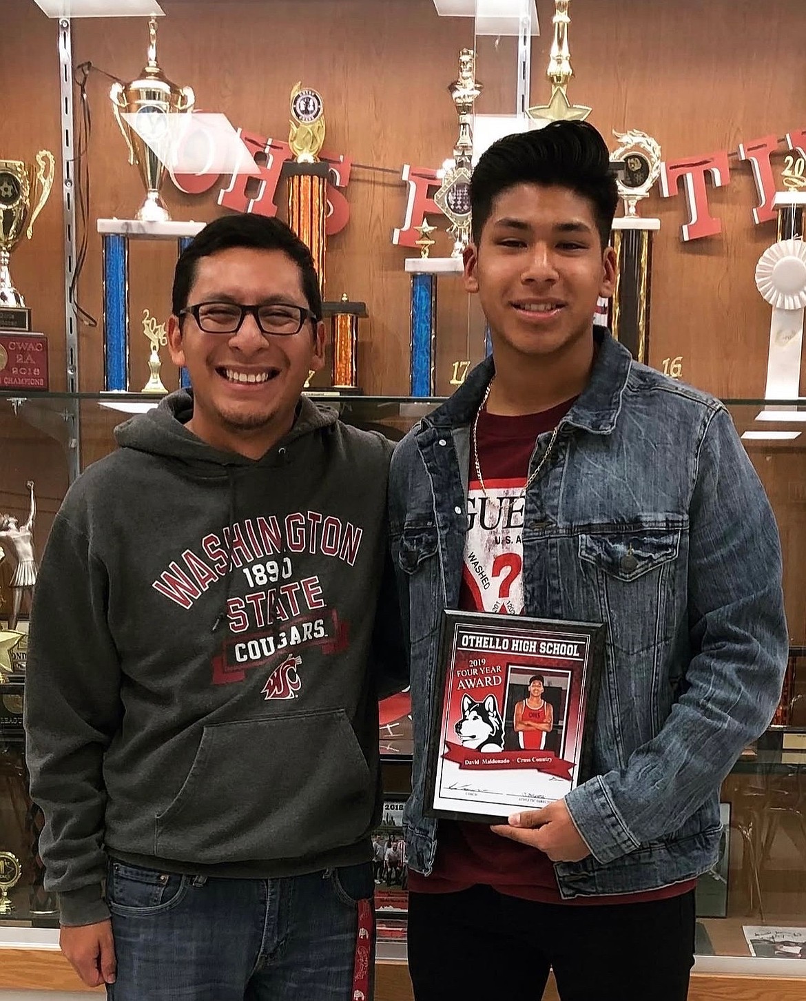 David Maldonado (right) stands with his former coach Aurelio Guevara (left) after receiving his four year award his senior year at Othello High School. Maldonado has been named the new head coach of Huskies cross country.