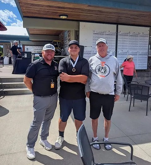 From left: Dillon Jahns, Eli Madigan and Mike Carlquist take a group photo at the 2026 1B state golf championships after Madigan received his fifth place medal.