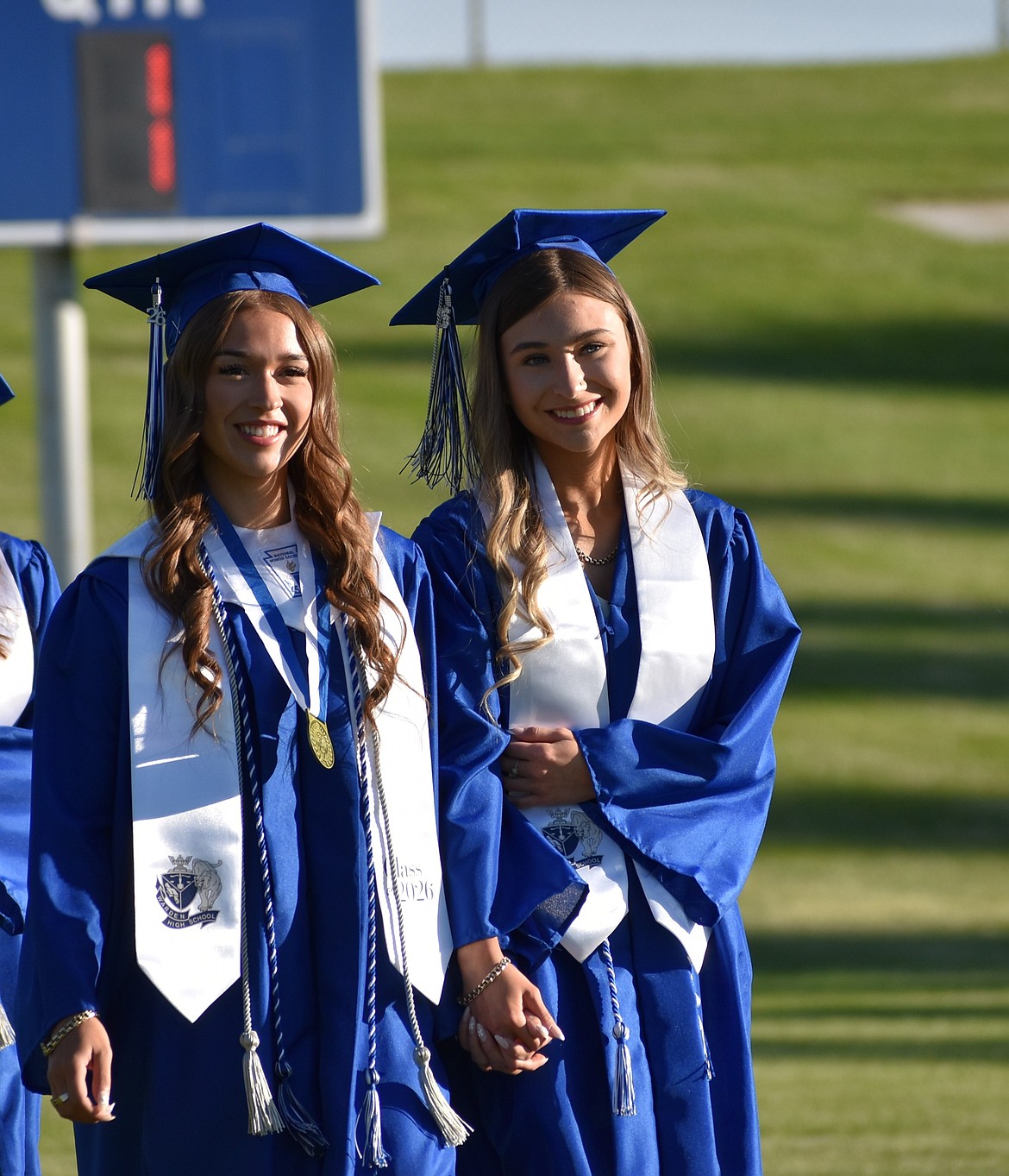 Miranda Martinez and Gabi Pruneda walk side by side onto the field at the start of the graduation ceremony.