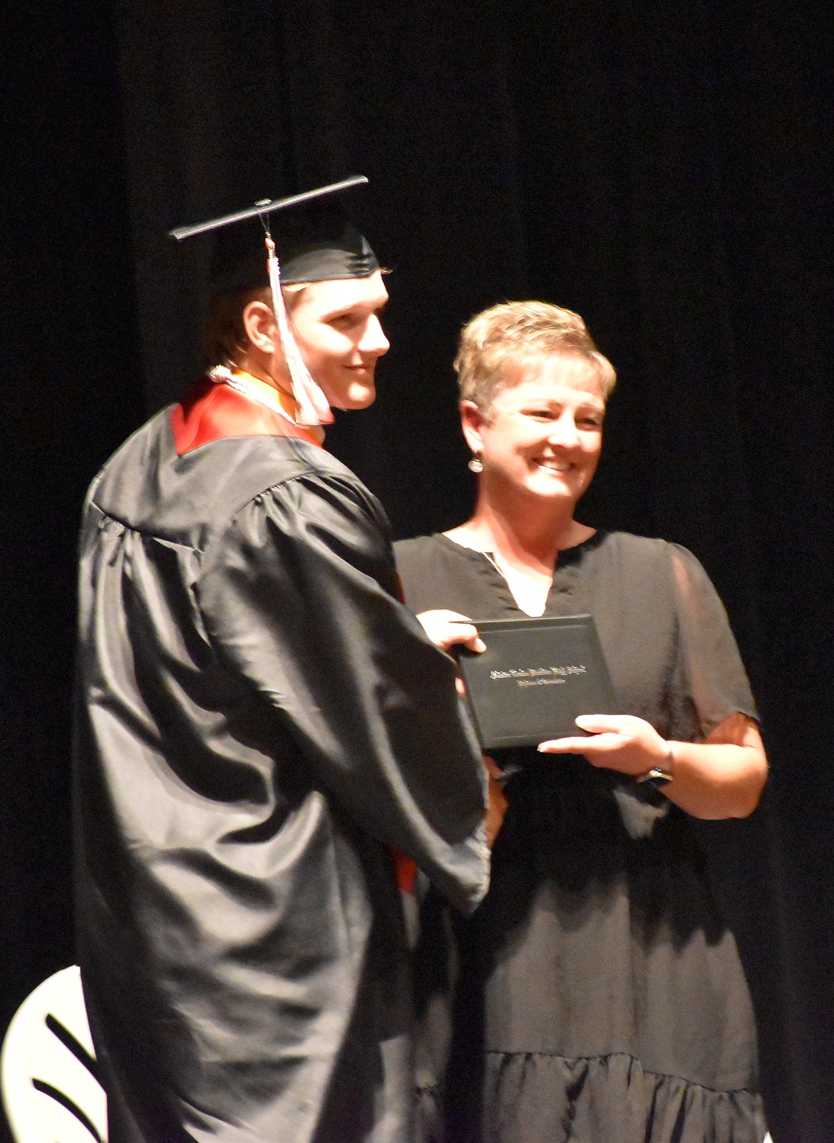 ACH’s Josh Booker shakes hands with Dawn Baergen as he receives his diploma for graduating high school.