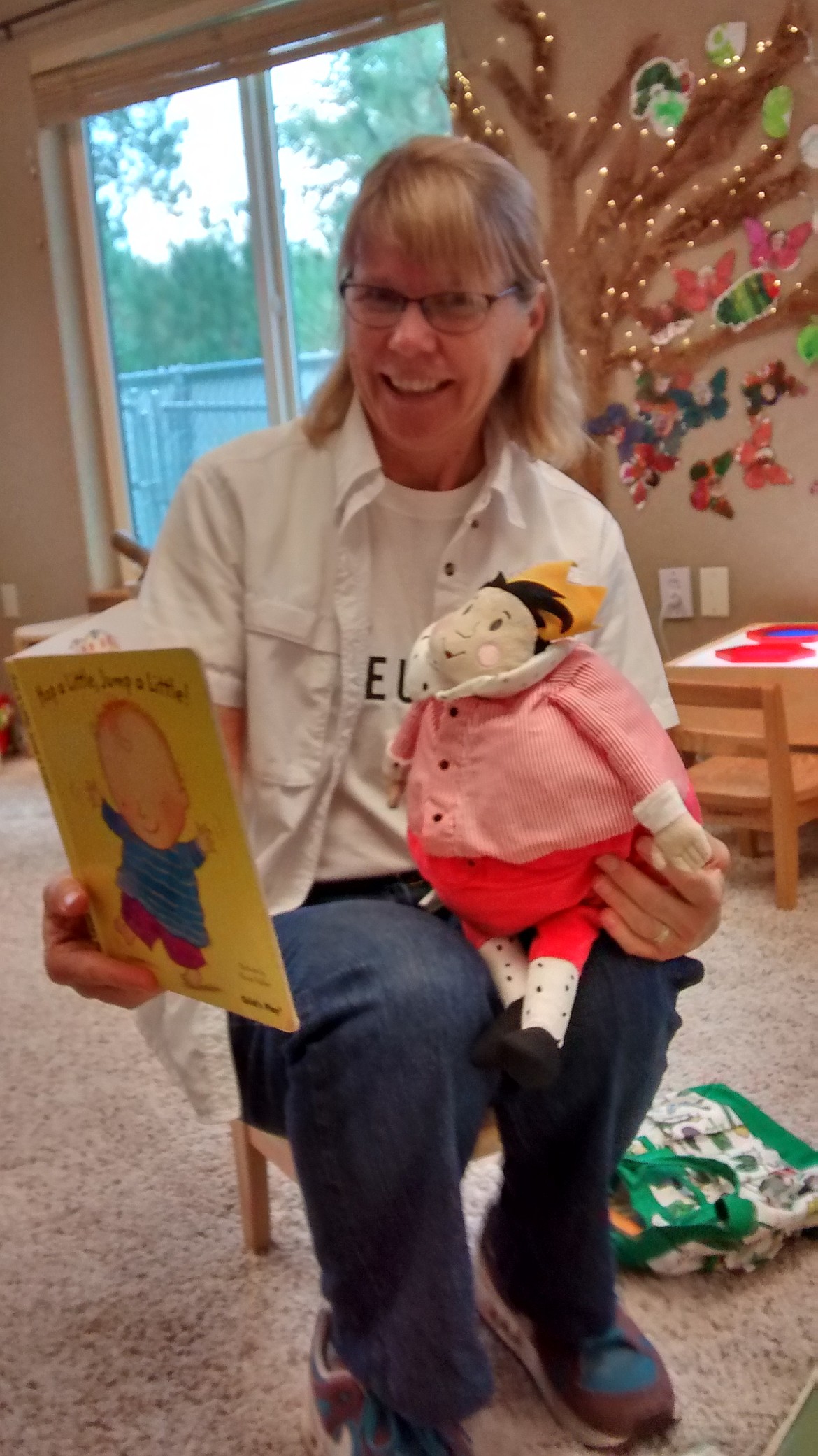 Annette Eberlein reads a book aloud to a stuffed animal at a children's event.