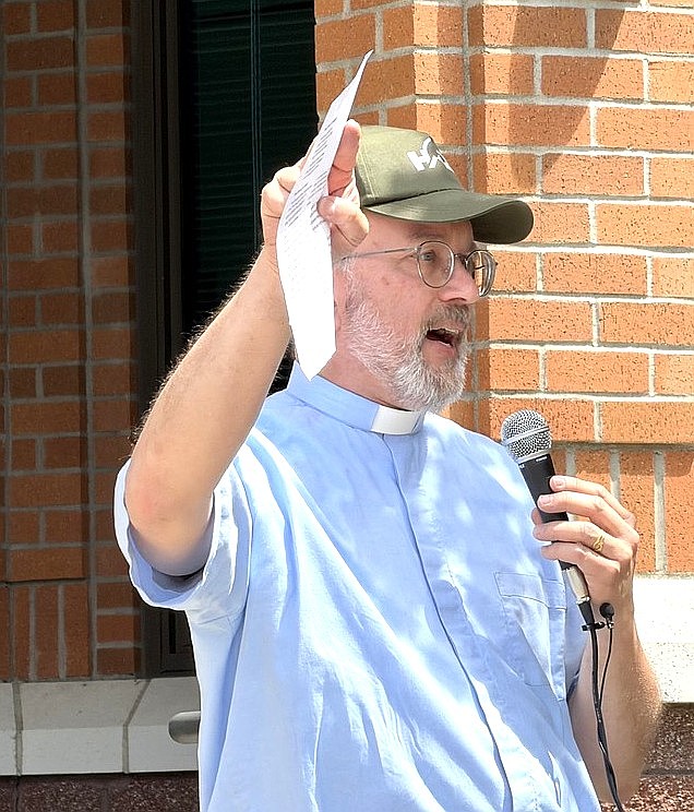 Priest David Gortner leads the crowd in singing "Glory, Glory, Hallelujah".