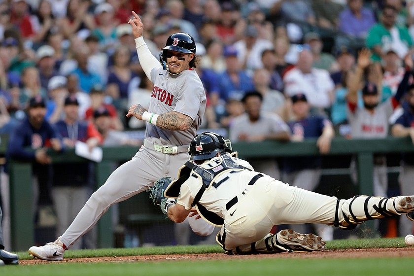 Boston Red Sox's Jarren Duran scores with Seattle Mariners catcher Cal Raleigh reaching with an empty glove during the seventh inning of a baseball game, Friday, June 19, 2026, in Seattle.
