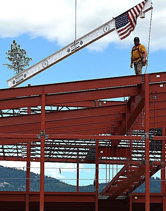 The tallest beam is hoisted up on the structure for the new Rathdrum City Hall as part of a "tree topping" ceremony on Thursday. Jake Jordan prepares to position the beam while Cody VanDuyne climbs up to join him.