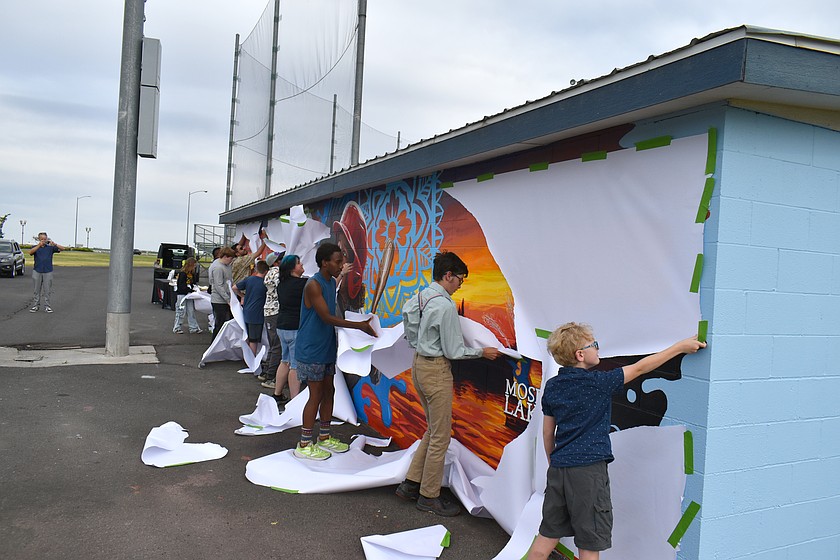 The young artists who created a mural at the Paul Lauzier Athletic Complex unveiled it Tuesday.