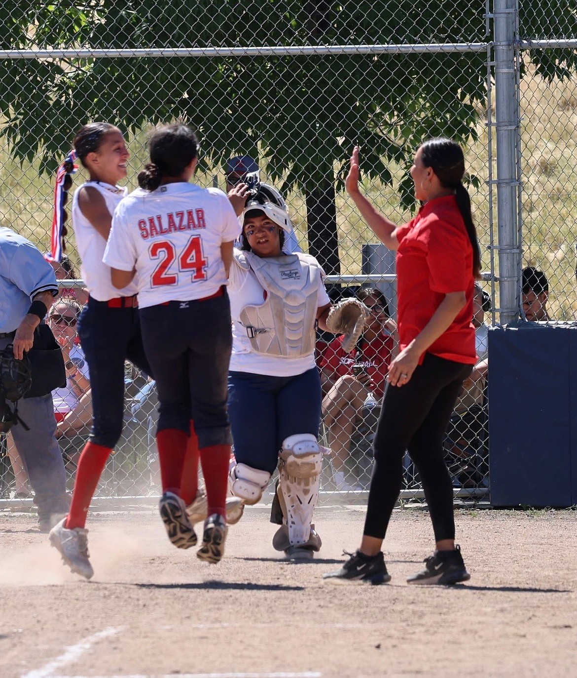 Othello Head Coach Cynthia Ochoa Garza runs up to high five her players on home plate during the District 5 tourney.
