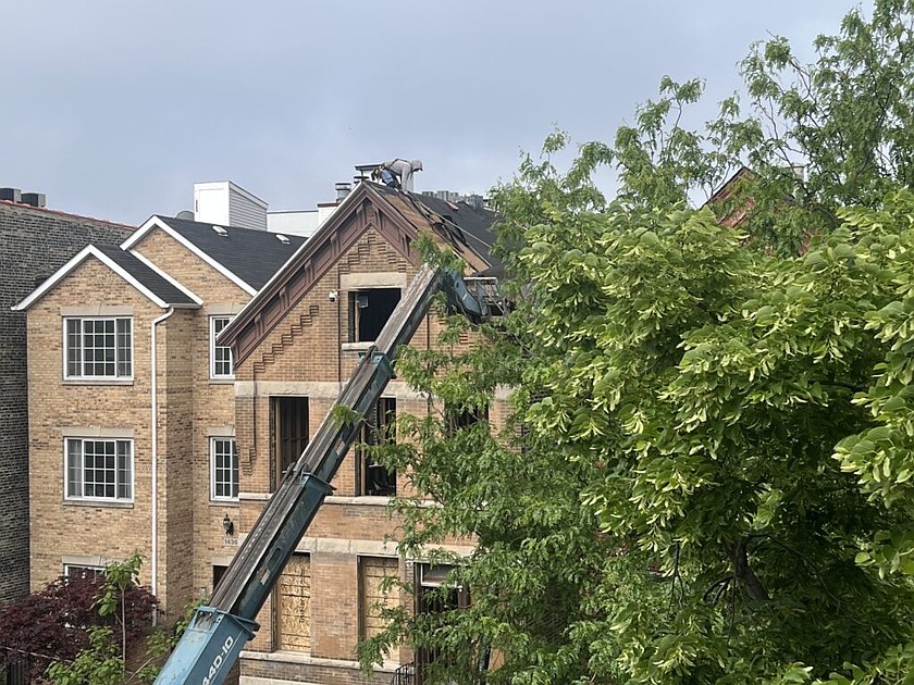A construction worker balances atop a roof. States and cities are loosening building code requirements in an effort to lower construction costs and boost affordable housing.