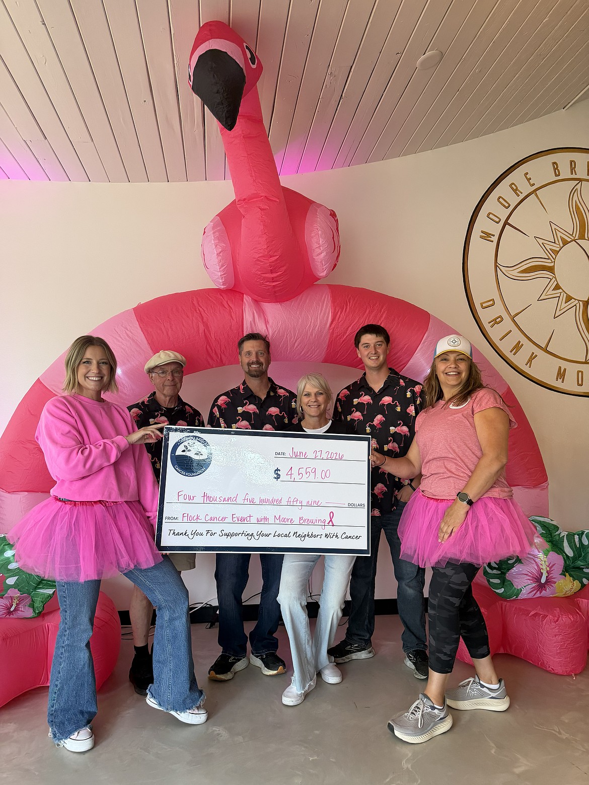 Moore Brewing Staff and Columbia Basin Cancer Foundation staff hold the check of the funds raised at the second annual Flock Walk.